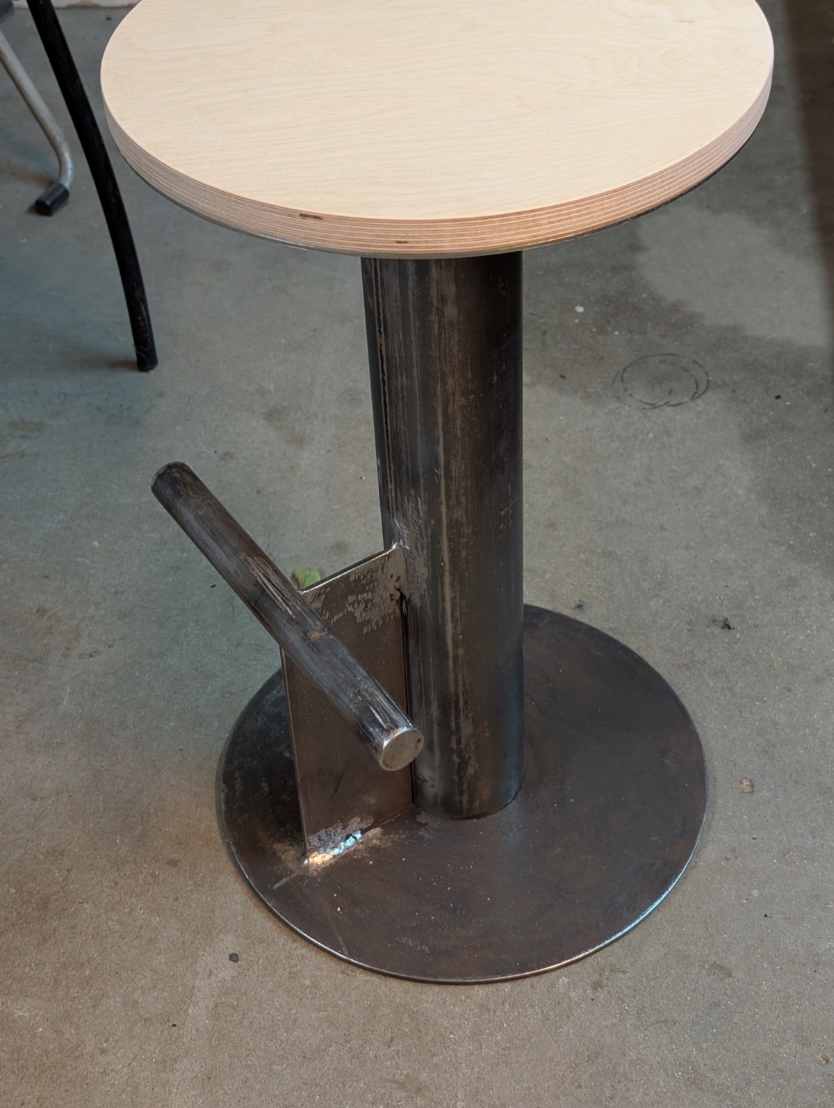 The bare steel base with welds ground smooth, plywood seat already fitted