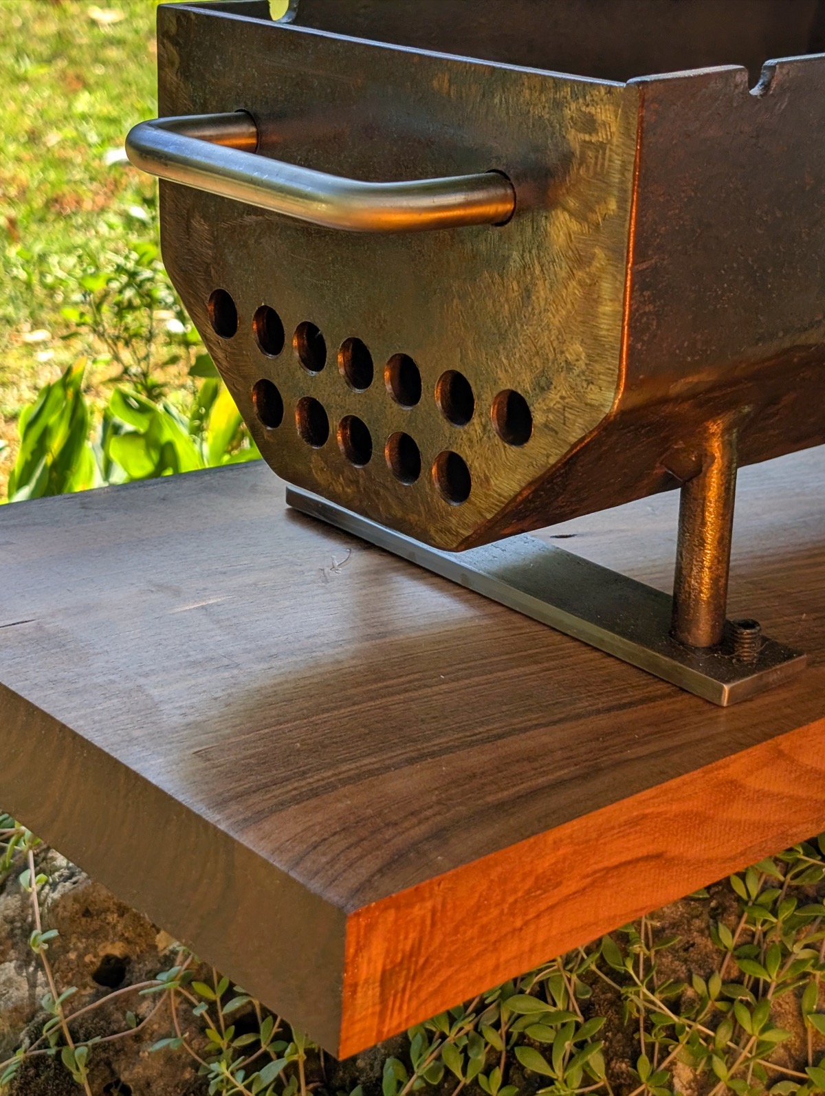 Close-up of the airflow holes, handle and foot on the mounted firebox