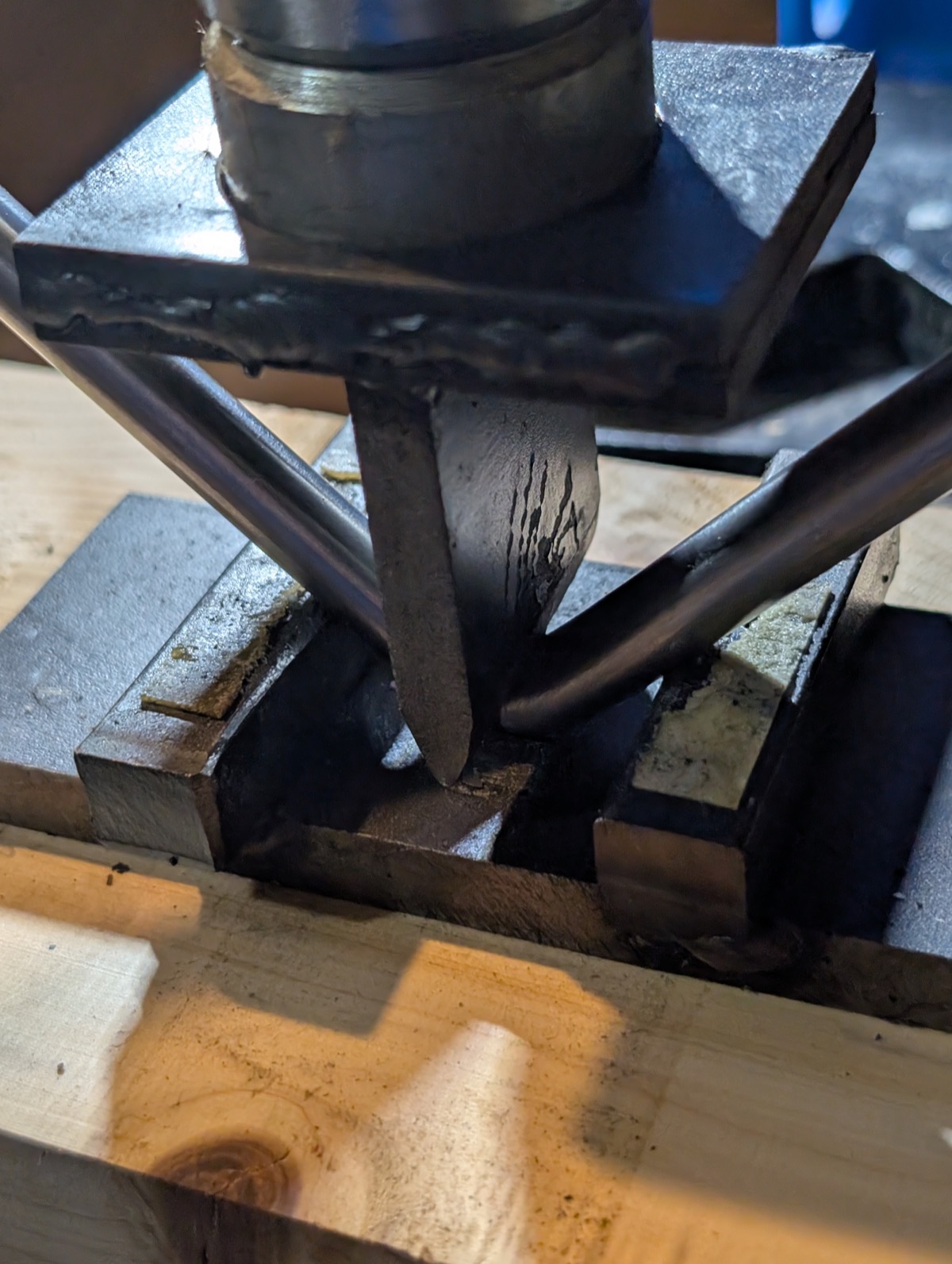 A hand operated hydraulic press bending a steel rod into a handle