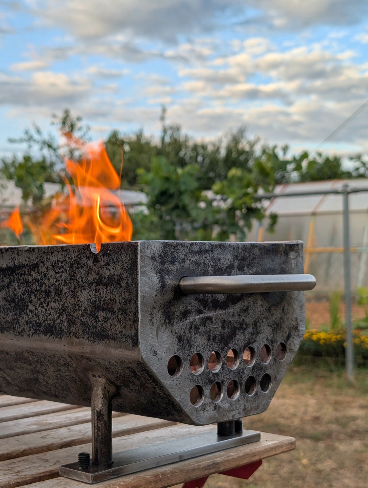 The first fire, flames rising from the empty firebox outdoors