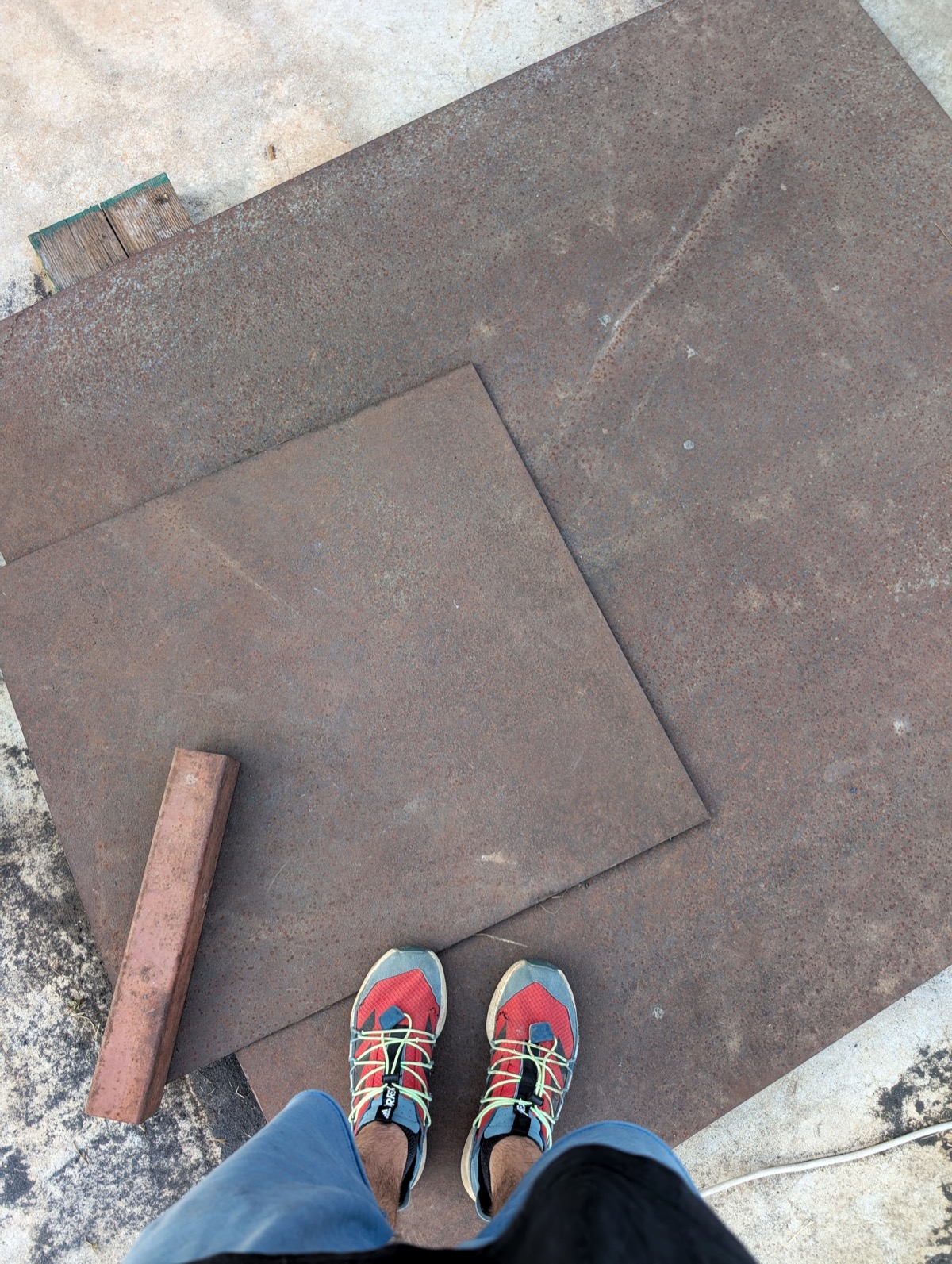 A steel plate leaning outdoors, the raw material for the build