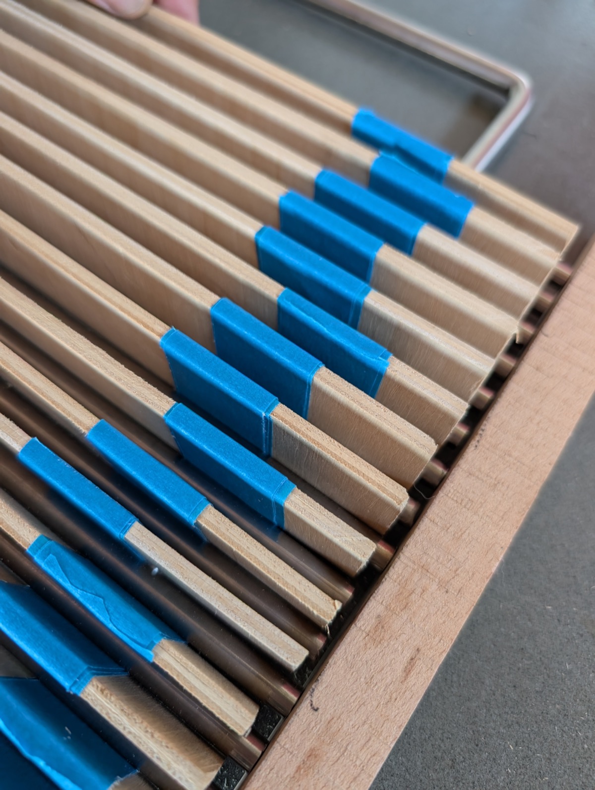 Wooden spacer strips holding the grate rods evenly spaced in their frame before welding