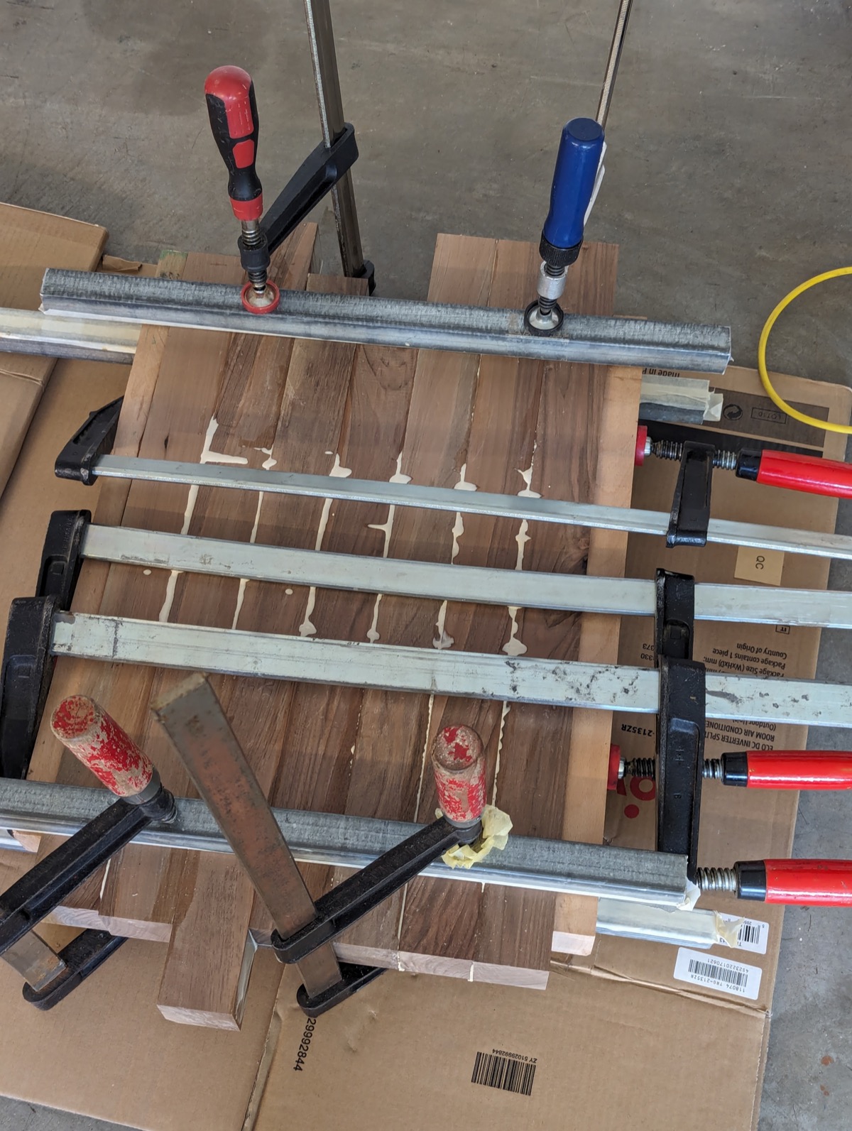 The checkerboard panel under F-clamps and bar clamps, glue squeezing out