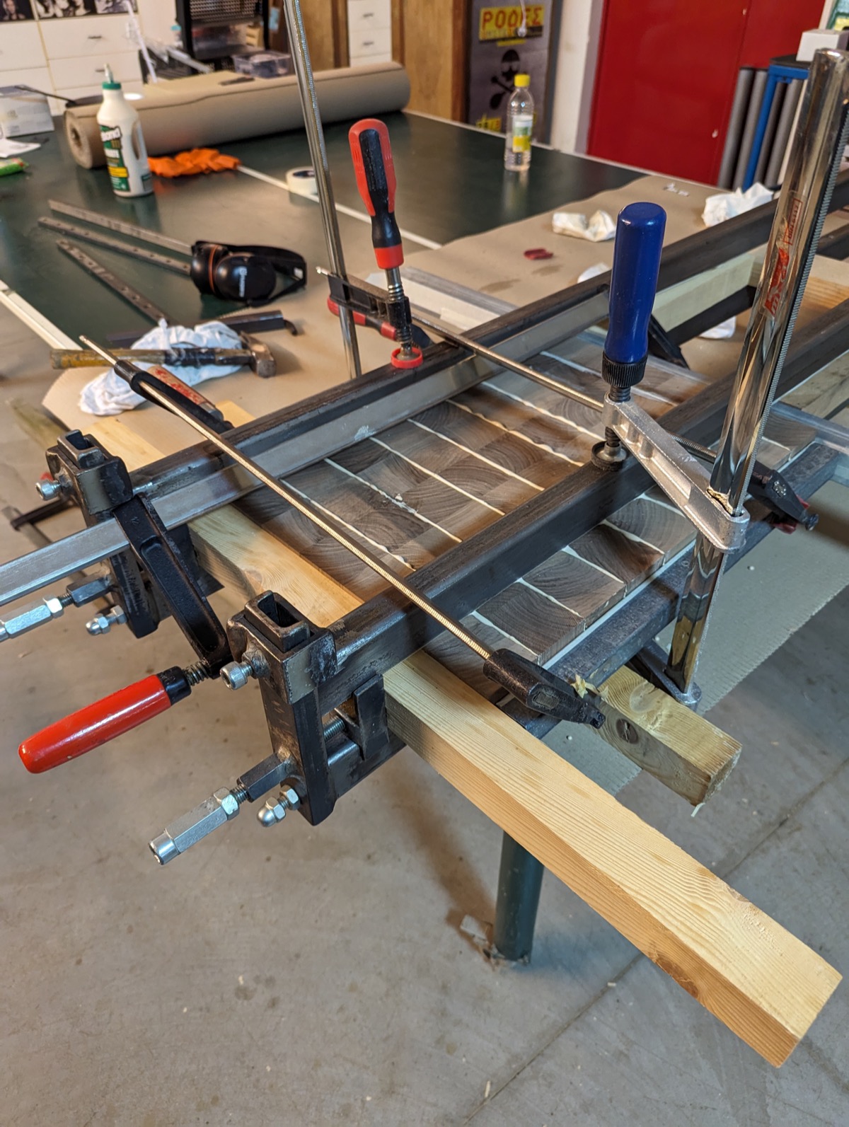 The panel clamped flat between pipe clamps and wooden cauls