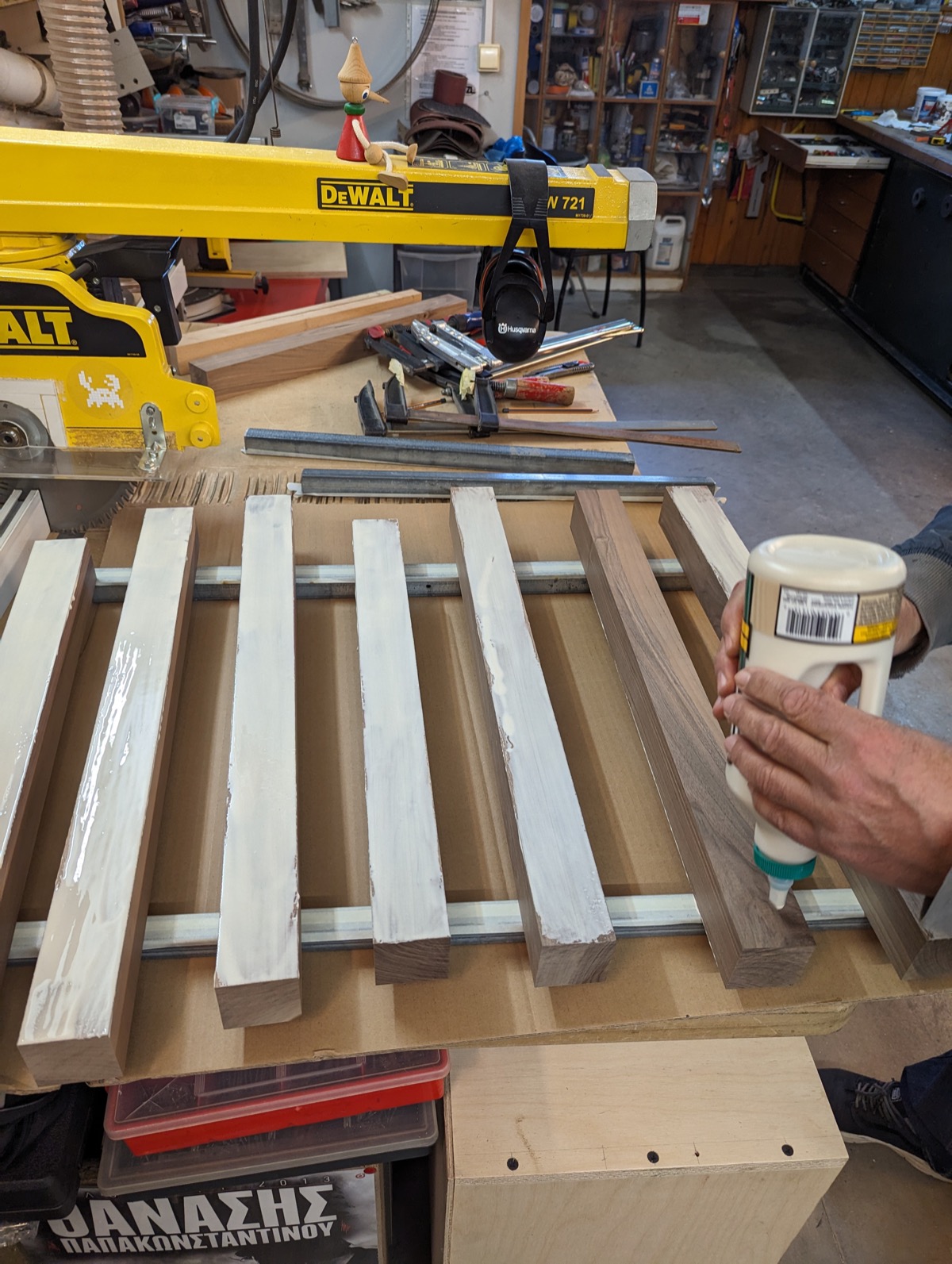 Strips clamped on the bench with glue applied, radial arm saw behind