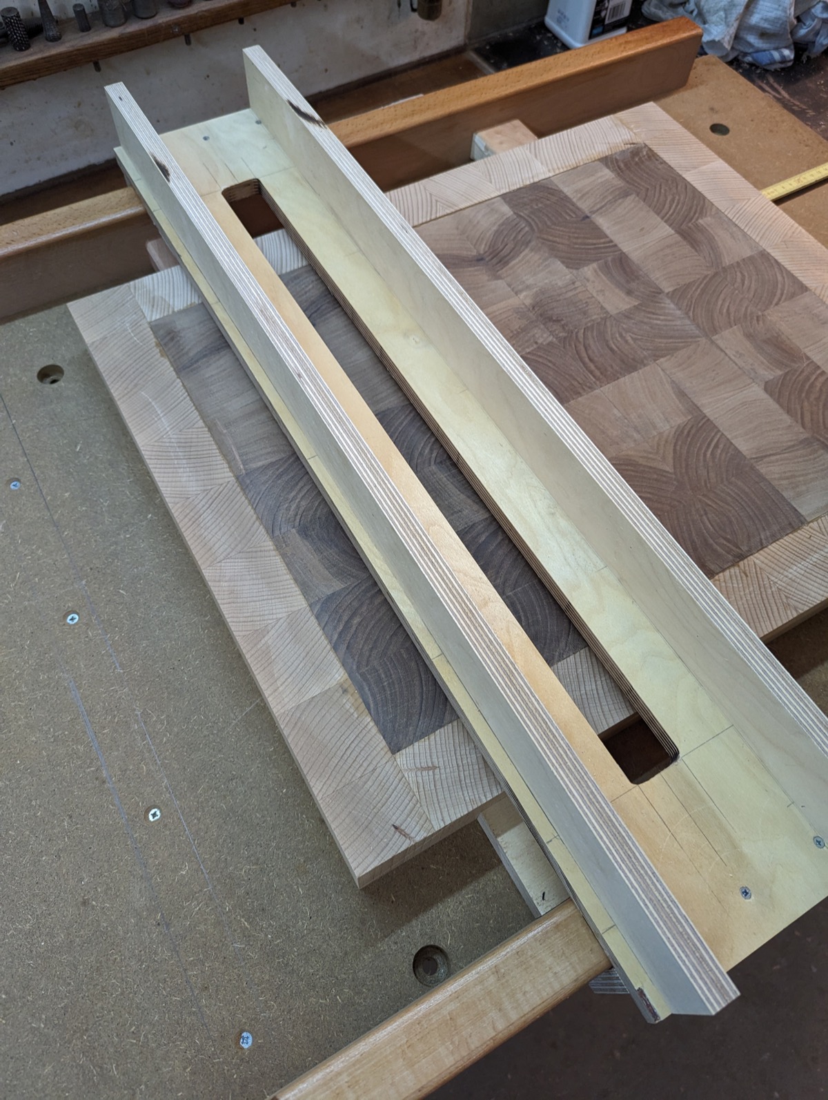 A router sled jig set up over the panel on the bench