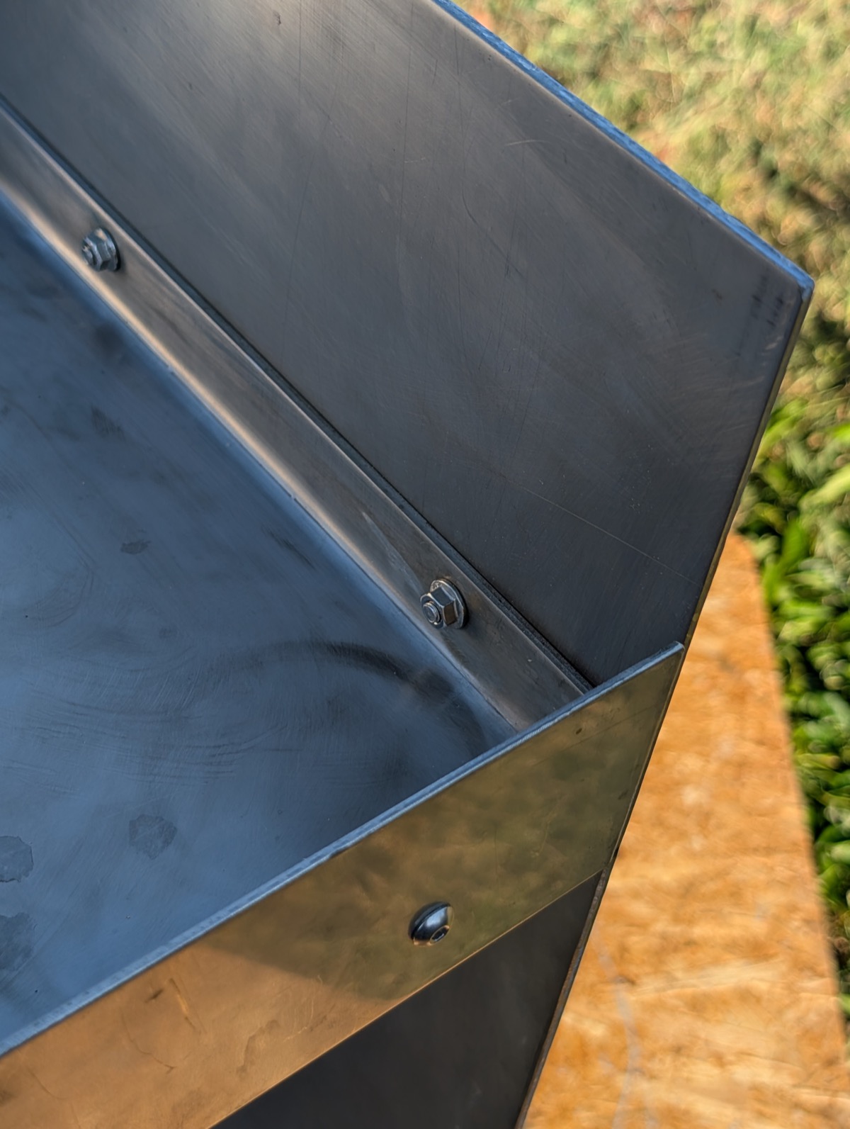 Close-up of a bolted corner joint with a deliberate gap