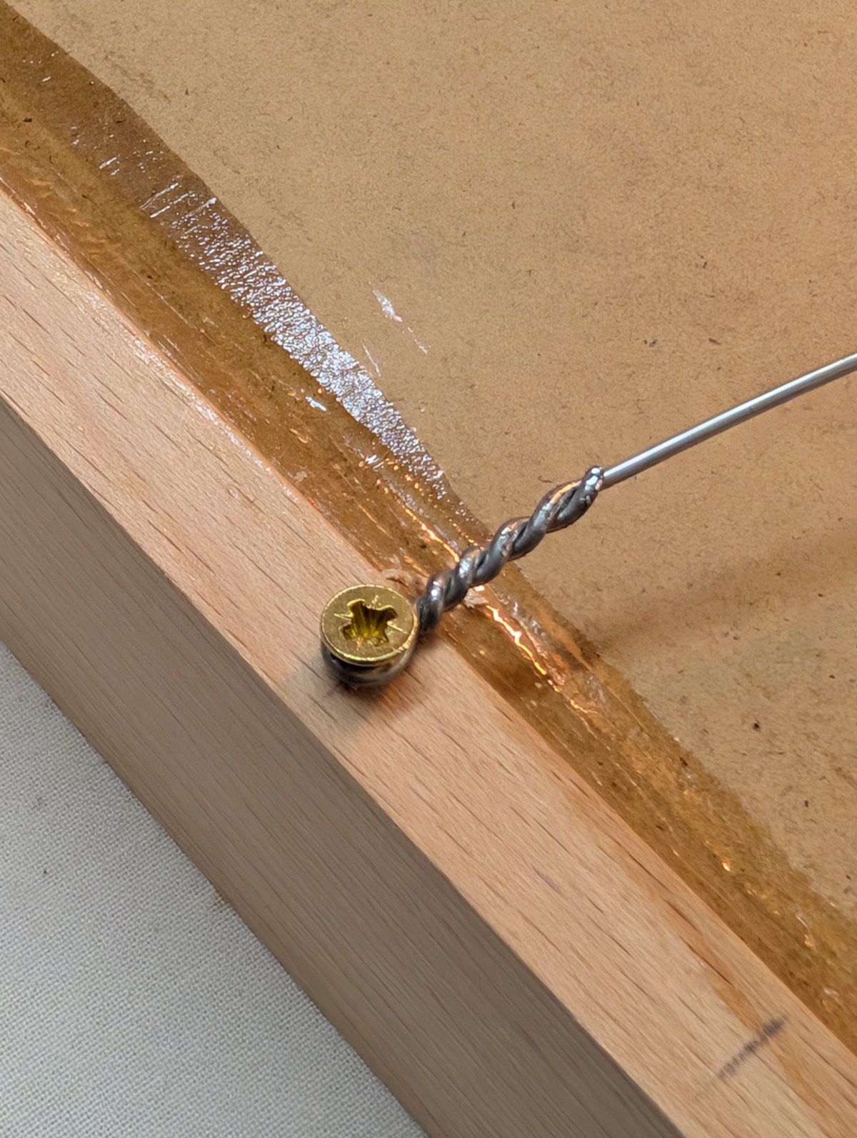 Close-up of a screw and glue at a beechwood frame corner joint
