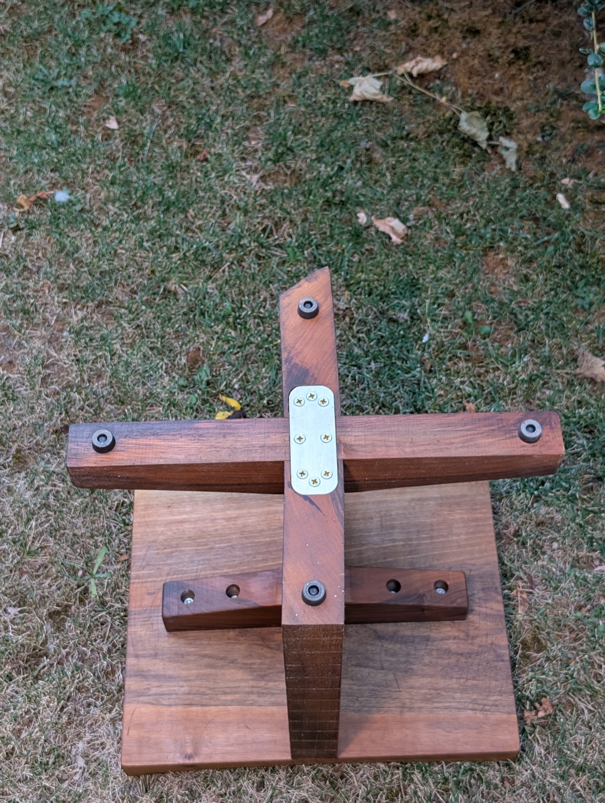 Underside of the stool base, showing the metal connector plate joining the legs